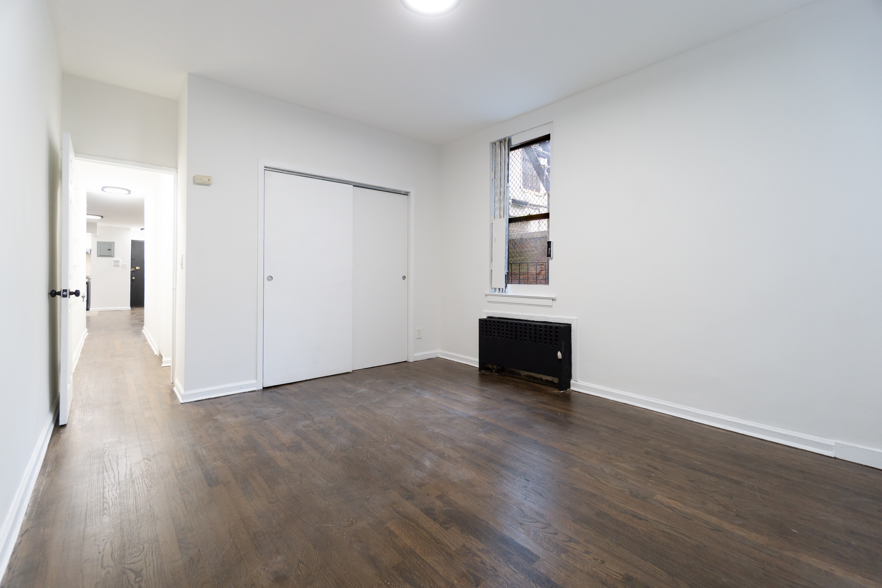 205 2nd Avenue, Unit 2C Manhattan, NY 10003 - Photo 4 of 15 an empty room with wooden floor and a window
