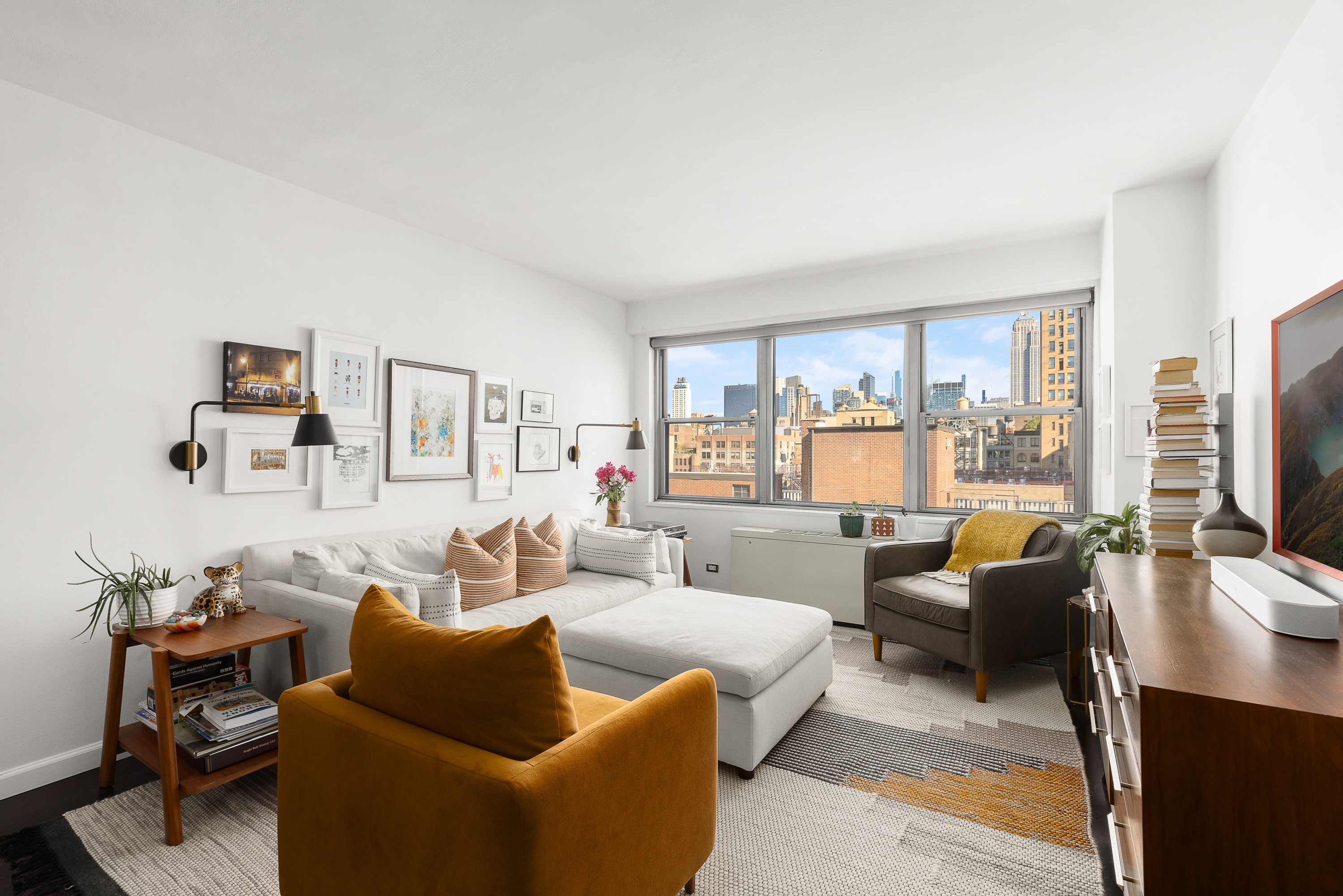 a living room with furniture flat screen tv and large window