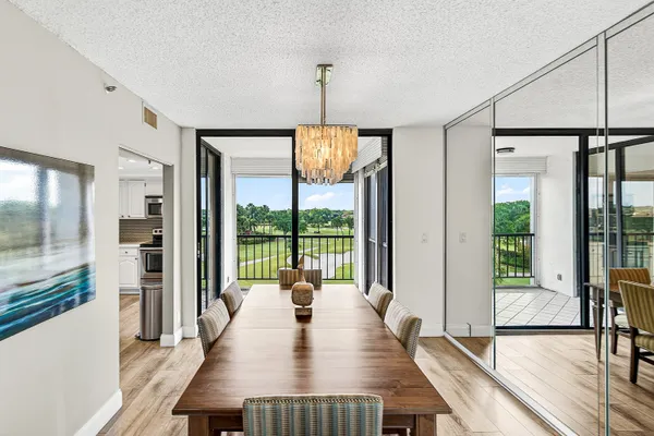 a view of a dining room with furniture large windows and wooden floor