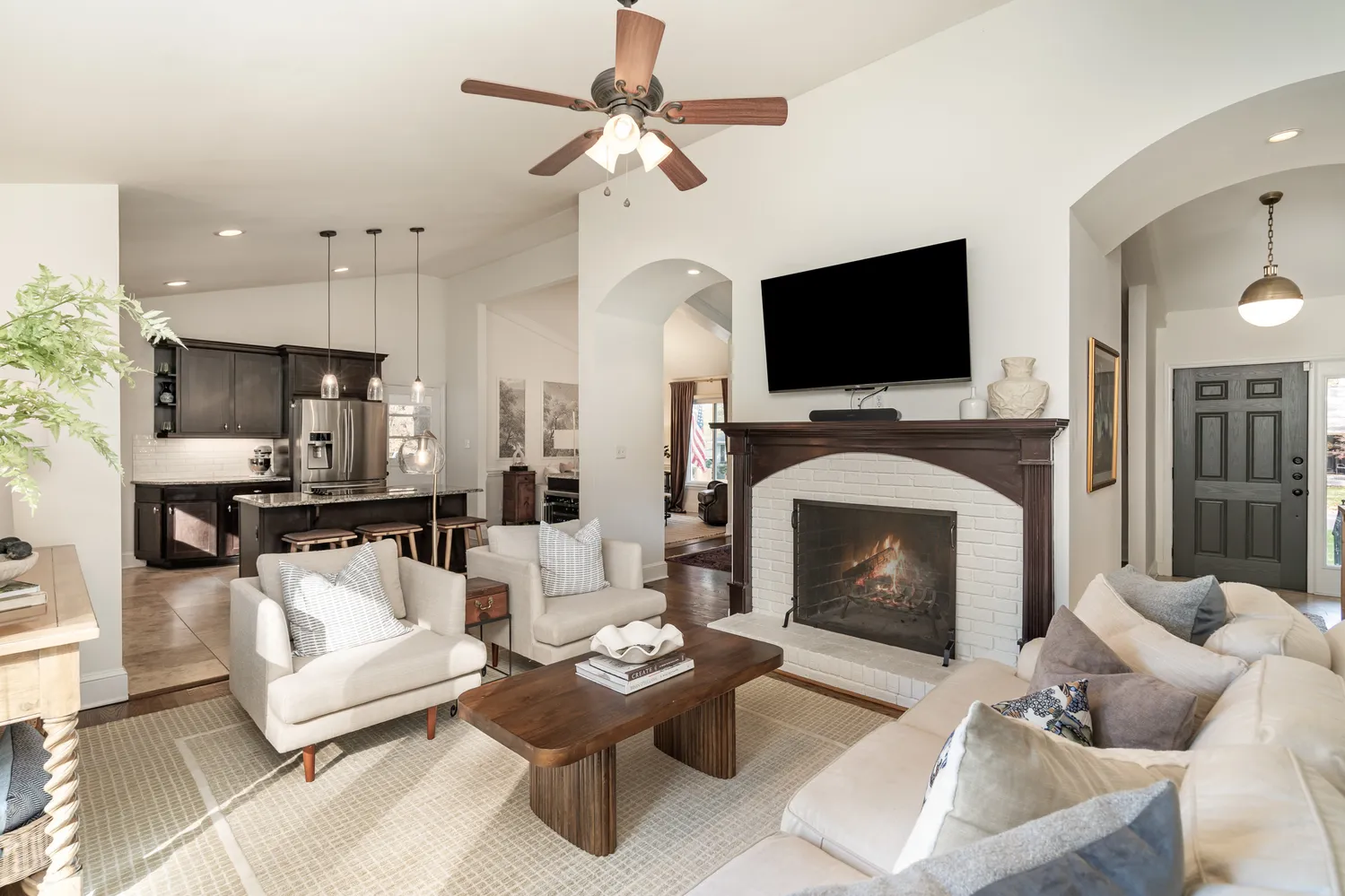 a living room with furniture a flat screen tv and a fireplace