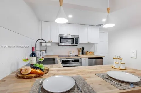 a kitchen with granite countertop a white stove and cabinets