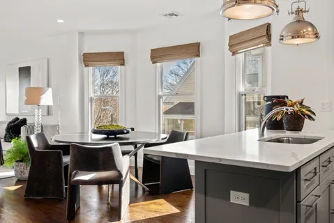 a kitchen with a table chairs sink and cabinets
