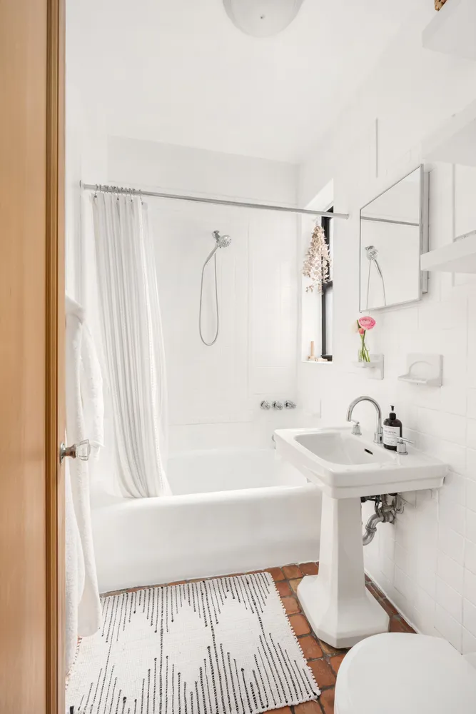 a front view of a building with lot of trees and plants