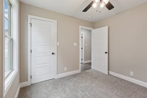 an empty room with windows and closet area