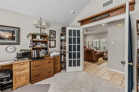 a walk in closet with clothes and shoes