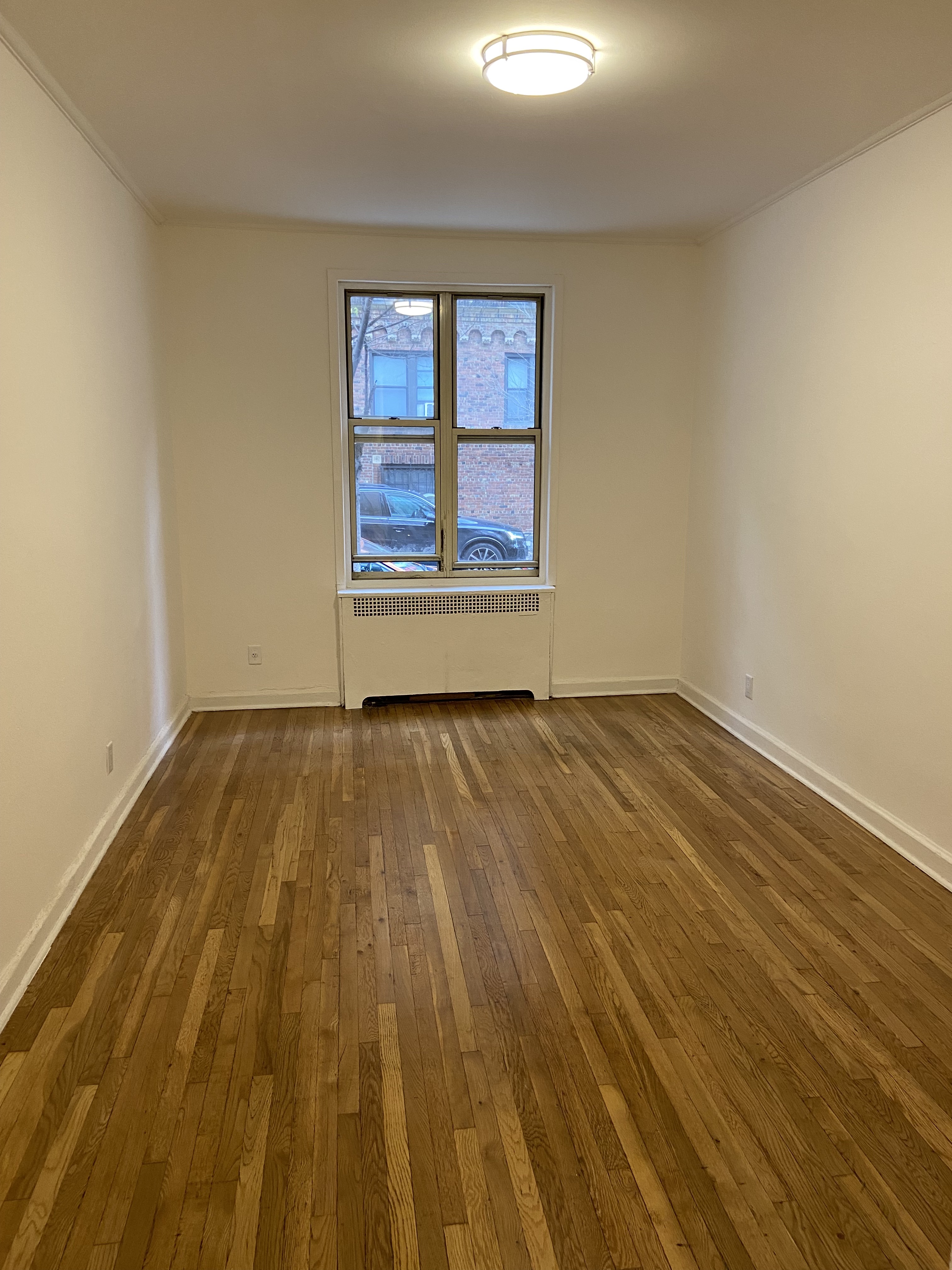 330 East 58th Street, Unit 1C Manhattan, NY 10022 - Photo 4 of 9 a view of empty room with wooden floor and fan