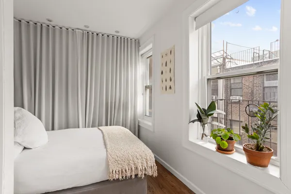 a bedroom with a bed and a potted plant