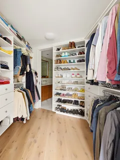 a view of walk in closet with clothes and shoes