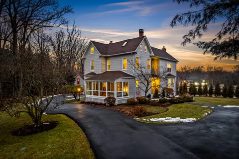 a front view of a house with yard and green space