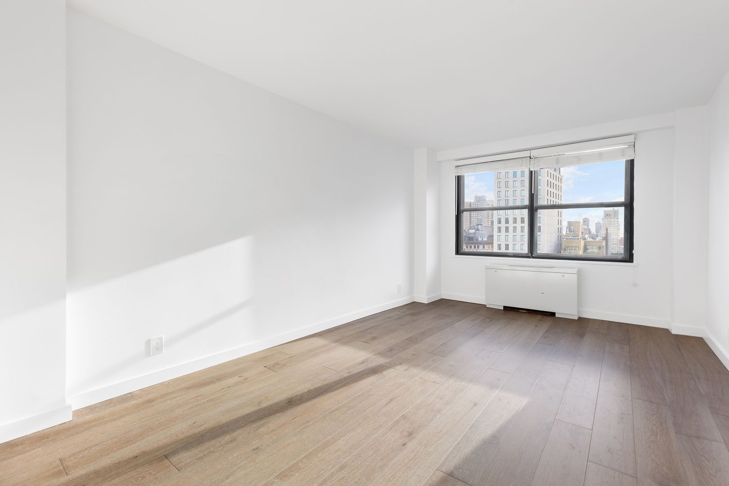 7 East 14th Street, Unit 17RS Manhattan, NY 10003 - Photo 5 of 9 an empty room with wooden floor and windows
