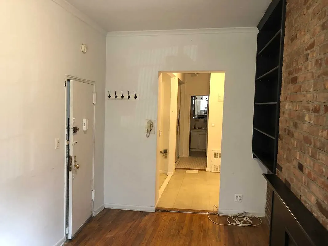 237 East 79th Street, Unit 1B Manhattan, NY 10075 - Photo 2 of 7 a view of a hallway with wooden floor and a bathroom