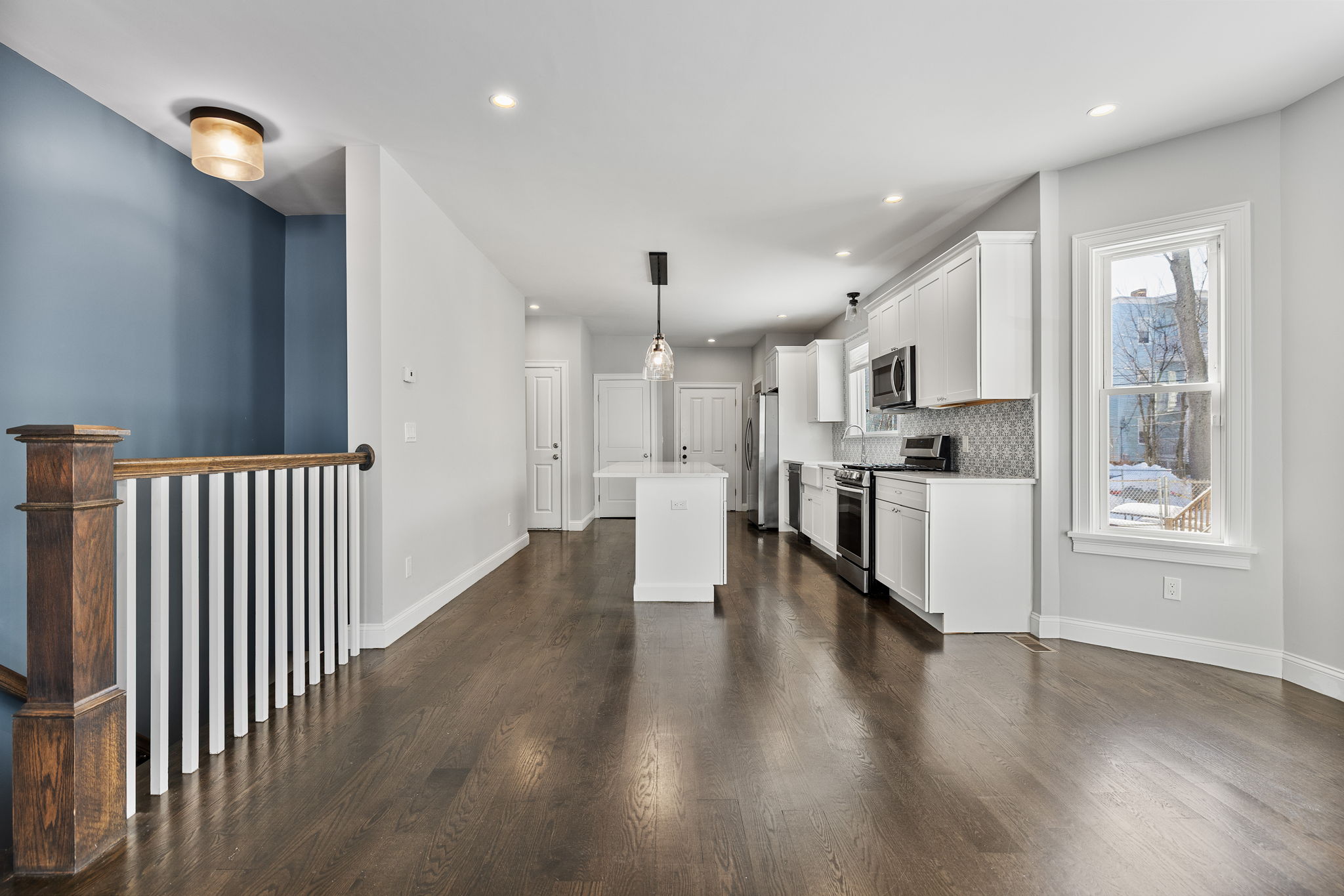 a view of a kitchen with wooden floor and electronic appliances