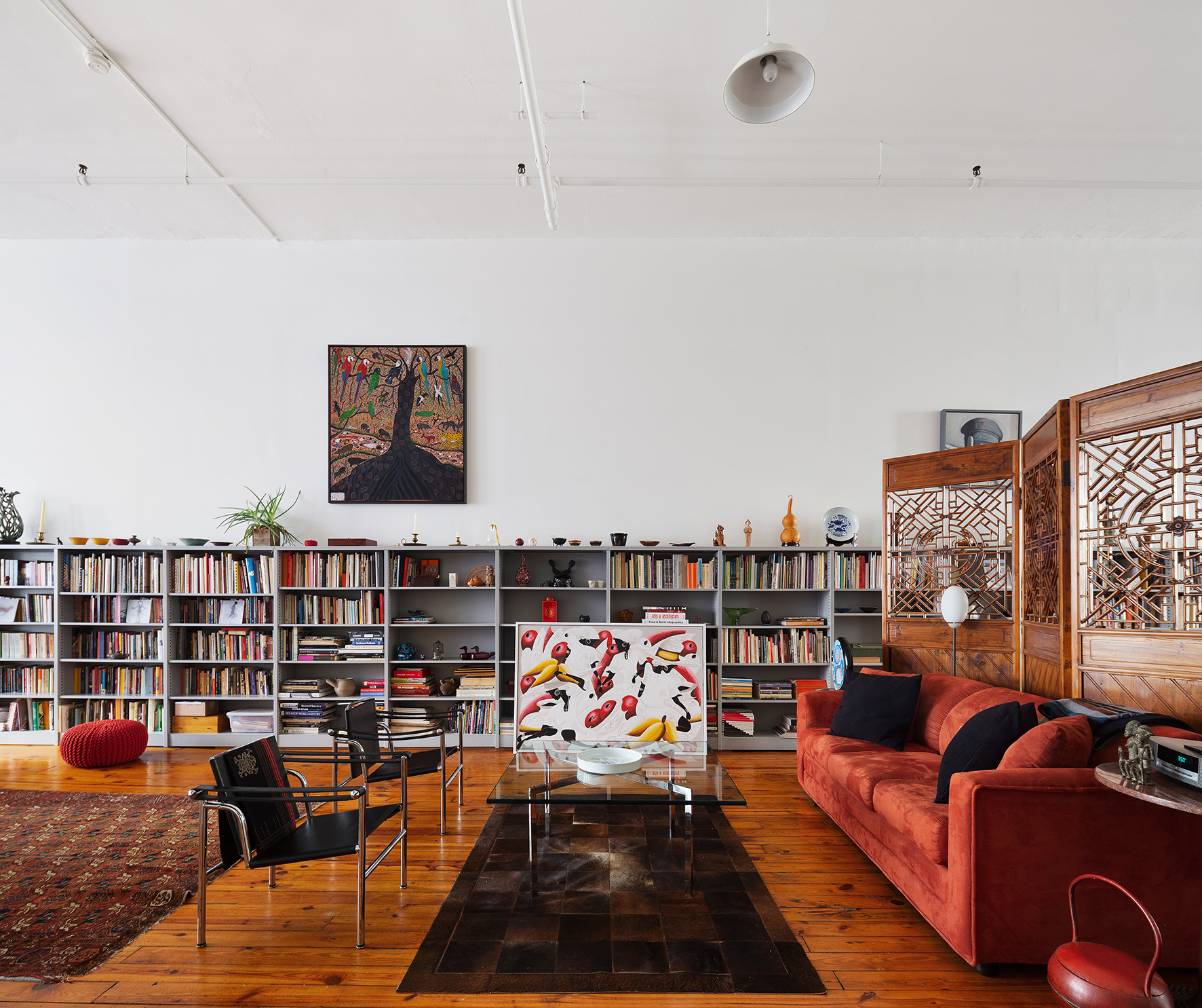 135 Greene Street, Unit 2N Manhattan, NY 10012 - Photo 4 of 13 a living room with furniture a rug and a book shelf