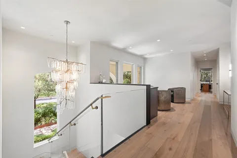 a view of a room with wooden floor kitchen view and windows