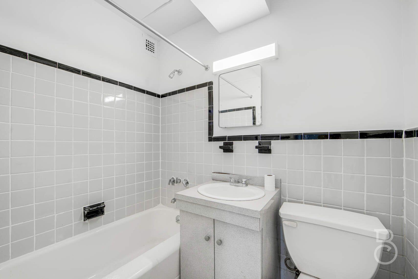 33-65 14th Street, Unit 5D Queens, NY 11106 - Photo 7 of 11 a bathroom with a sink a toilet and shower