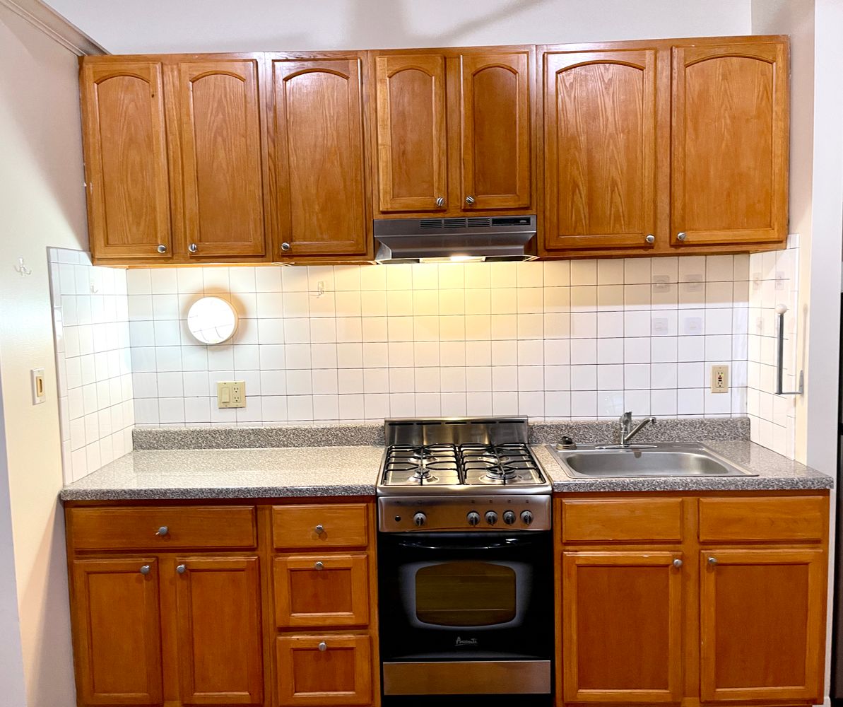 1672 Park Avenue Manhattan, NY 10035 - Photo 22 of 35 a kitchen with granite countertop cabinets and black appliances