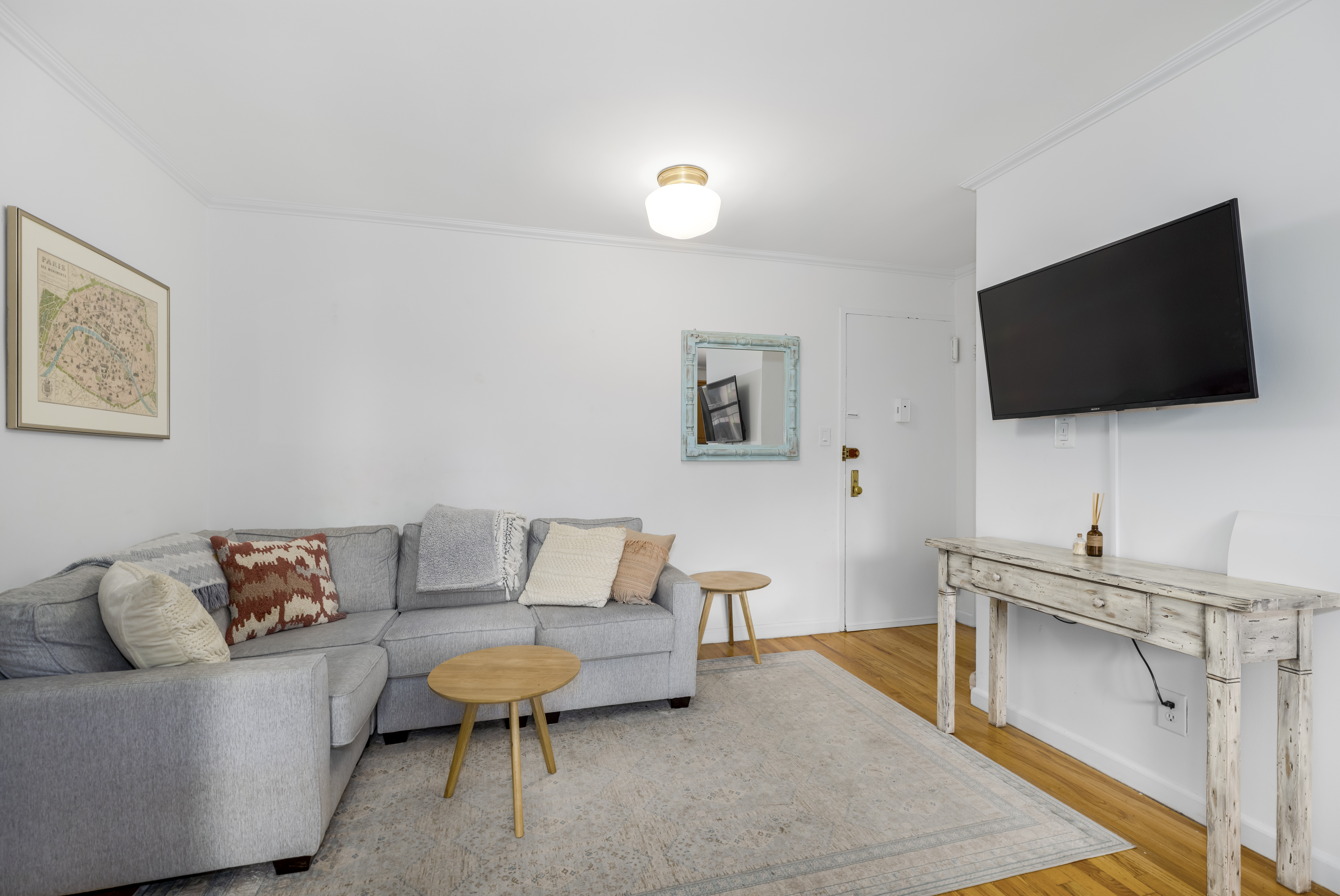 165 Christopher Street, Unit 3A Manhattan, NY 10014 - Photo 2 of 8 a living room with furniture and a flat screen tv
