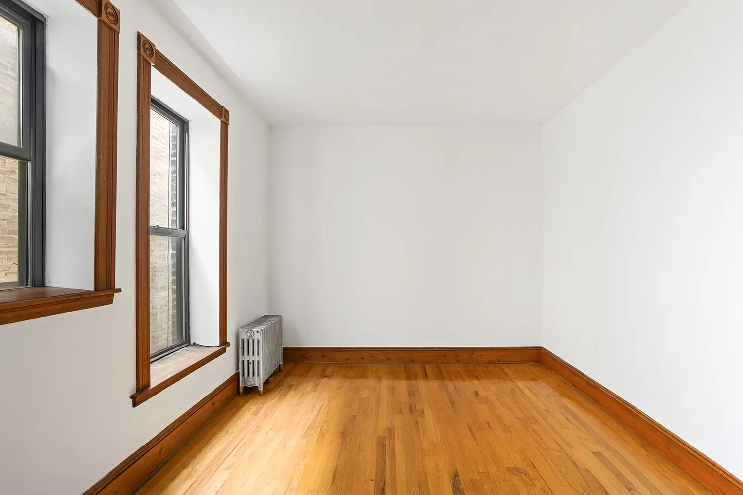 a view of a room with wooden floor and small window