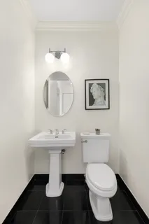 a bathroom with a toilet sink and mirror