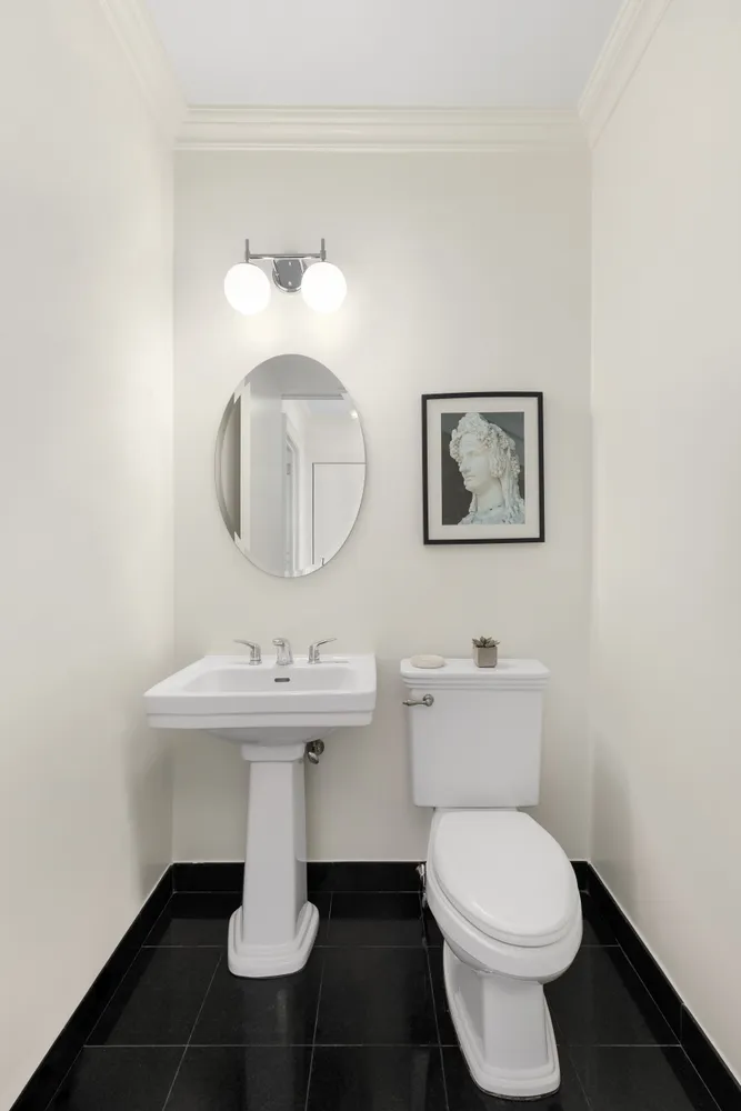 a bathroom with a toilet sink and mirror