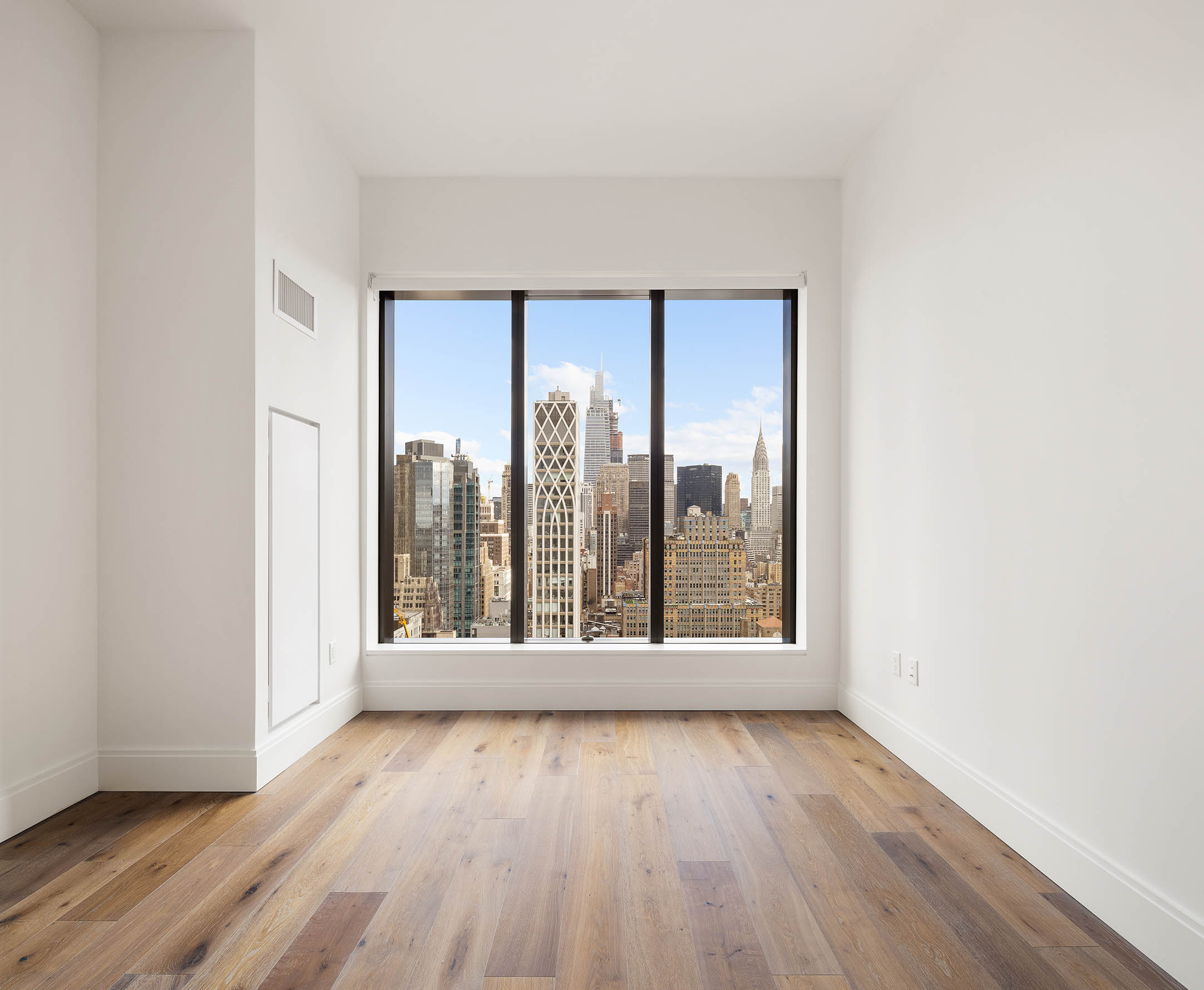 30 East 29th Street, Unit 31B Manhattan, NY 10016 - Photo 6 of 9 an empty room with wooden floor and windows