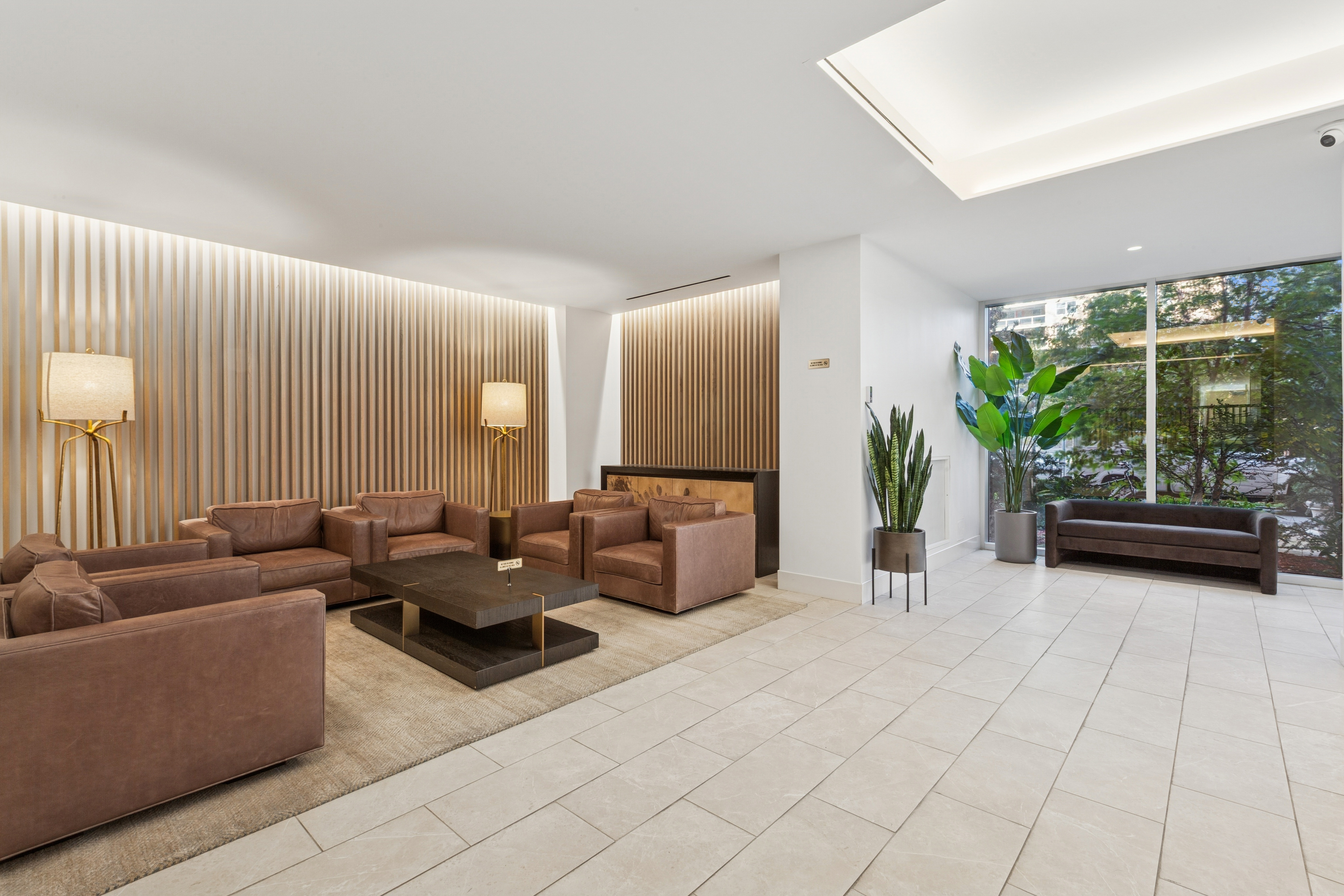 70-25 Yellowstone Boulevard, Unit 11D Queens, NY 11375 - Photo 8 of 25 a living room with furniture and a potted plant
