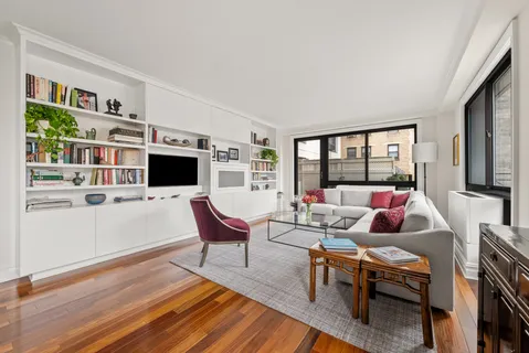 a living room with furniture flat screen tv and a table