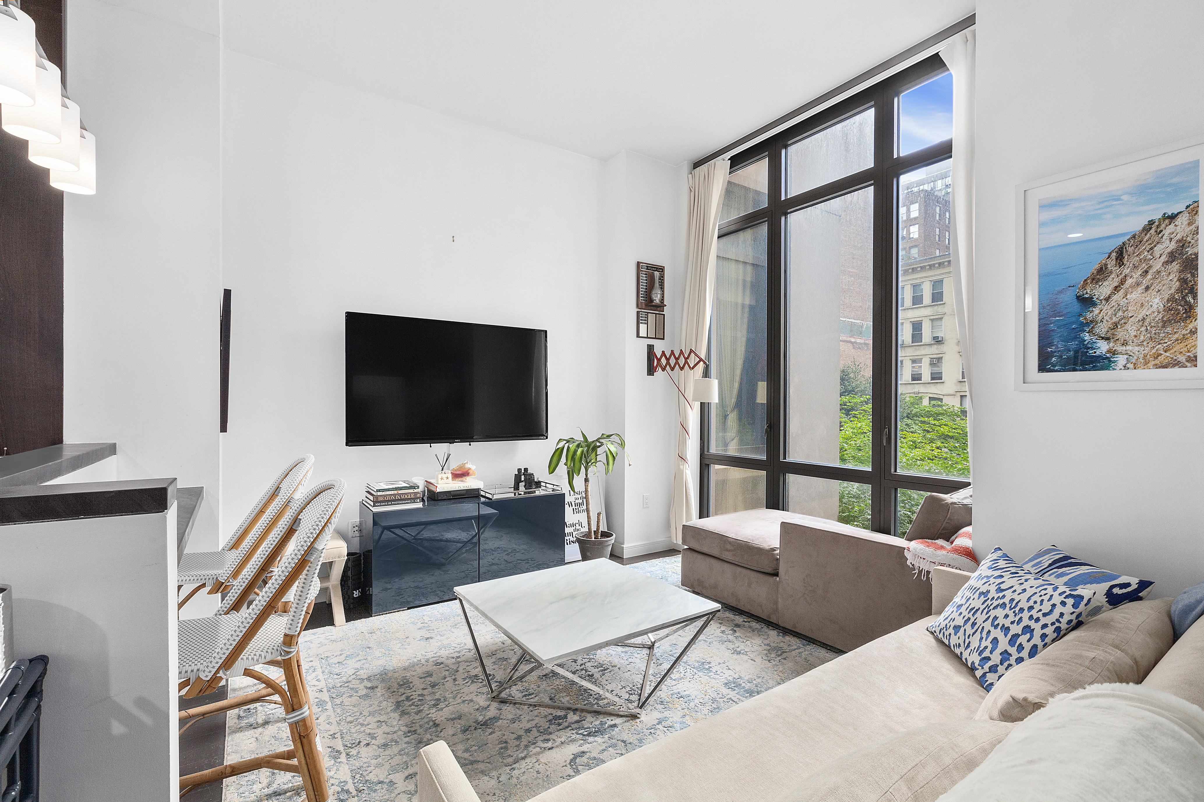 101 West 24th Street, Unit 4G Manhattan, NY 10011 - Photo 1 of 7 a living room with furniture and a flat screen tv