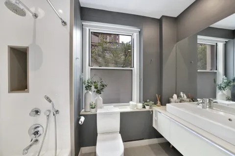a bathroom with a bathtub a sink and a large mirror