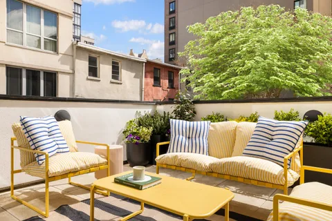a view of a patio with couches table and chairs and potted plants