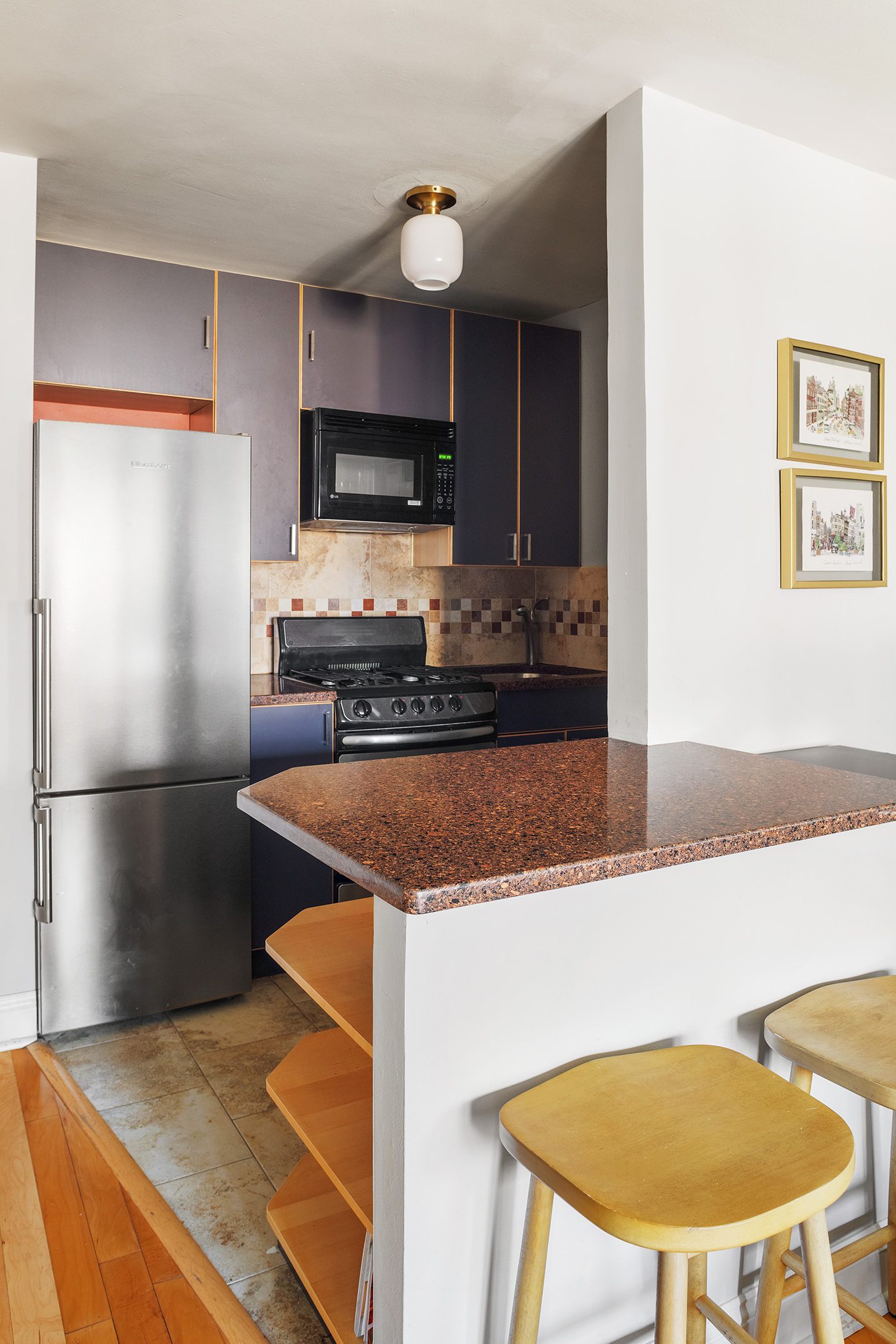 245 East 24th Street, Unit 9B Manhattan, NY 10010 - Photo 3 of 6 a kitchen with stainless steel appliances granite countertop a sink a refrigerator a microwave a stove and white cabinets