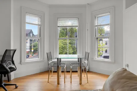 a view of a livingroom with furniture window and wooden floor