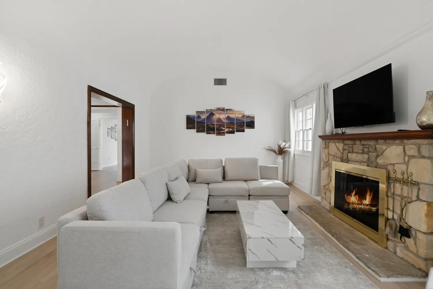 a living room with furniture a flat screen tv and a fireplace