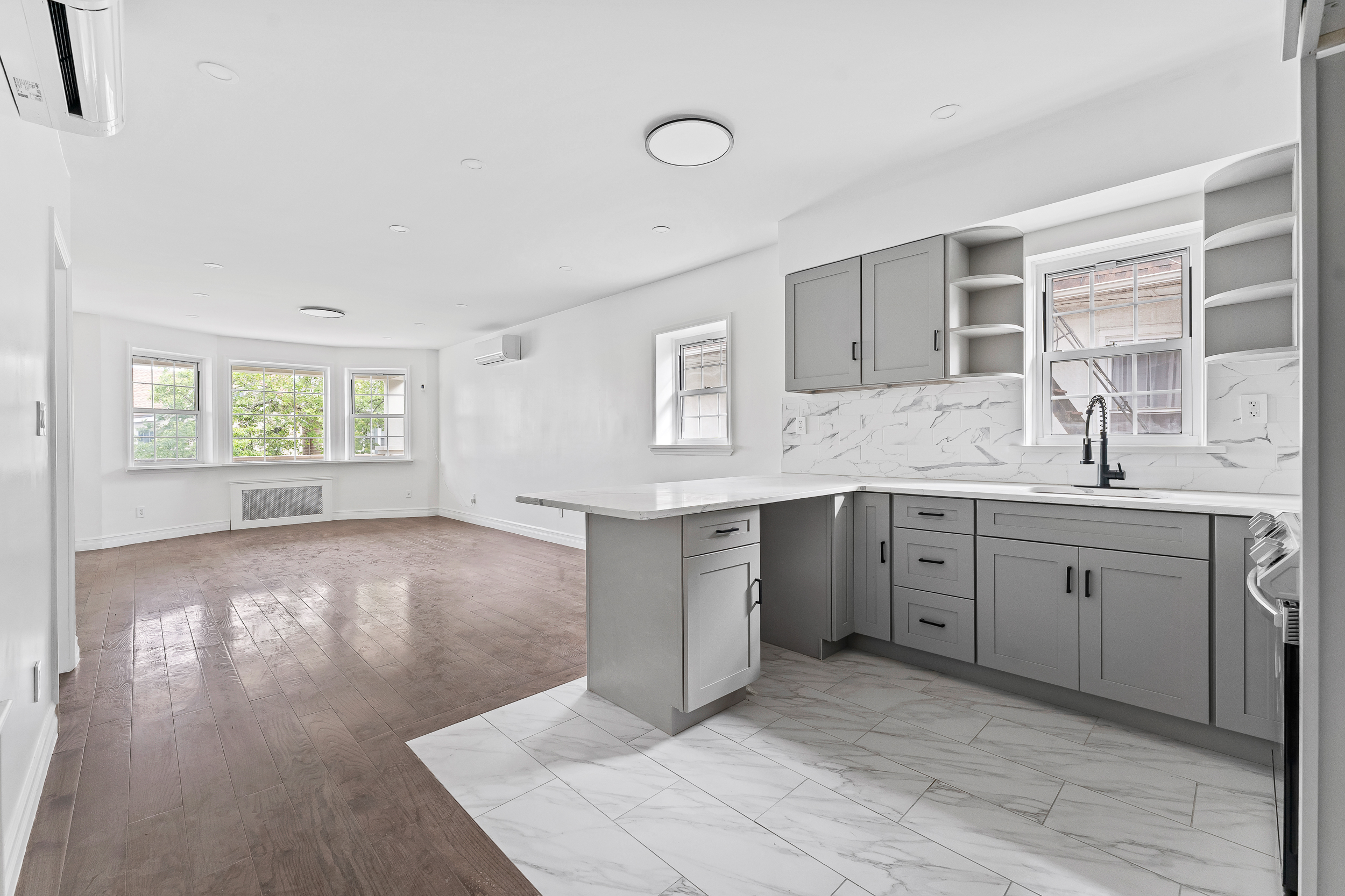 65 Bay 23rd Street, Unit 2 Brooklyn, NY 11214 - Photo 4 of 16 a spacious bathroom with a granite countertop sink mirror and window