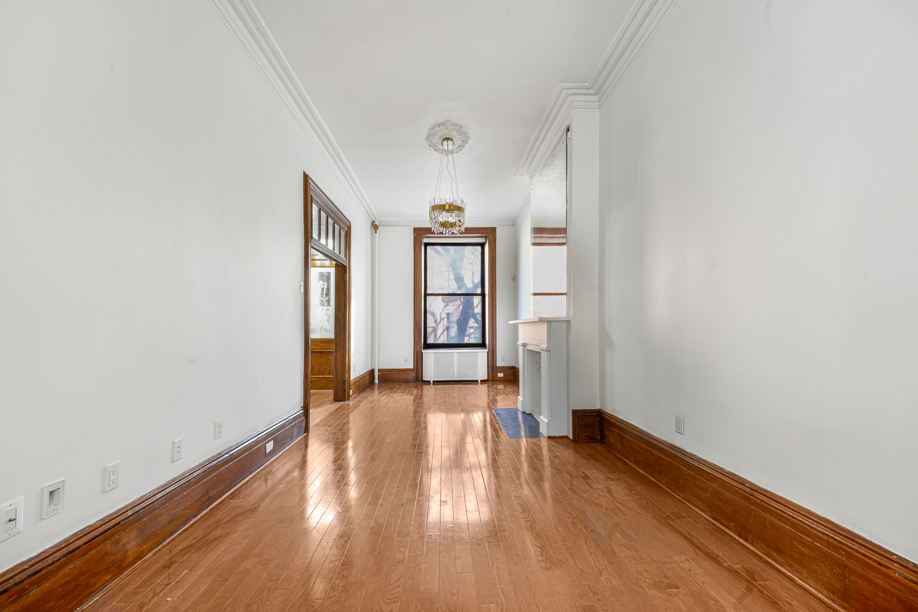458 West 153rd Street Manhattan, NY 10031 - Photo 5 of 21 an empty room with wooden floor and windows