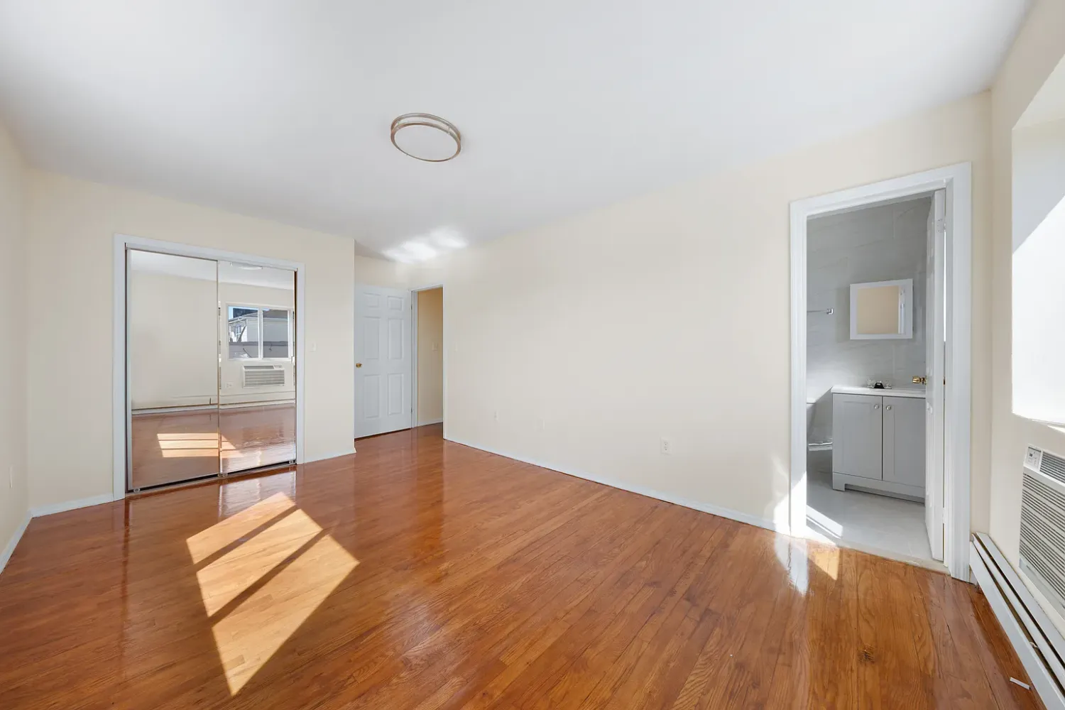 a view of a room with wooden floor and a bathroom
