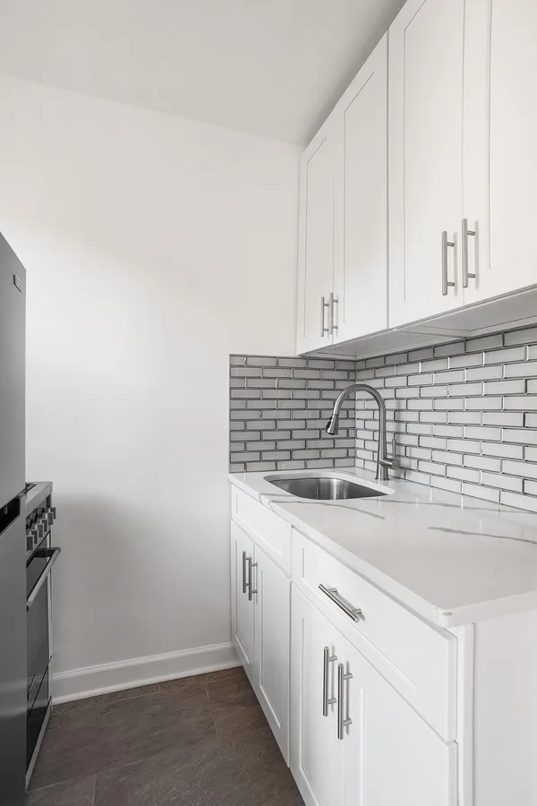 a kitchen with granite countertop white cabinets and white appliances