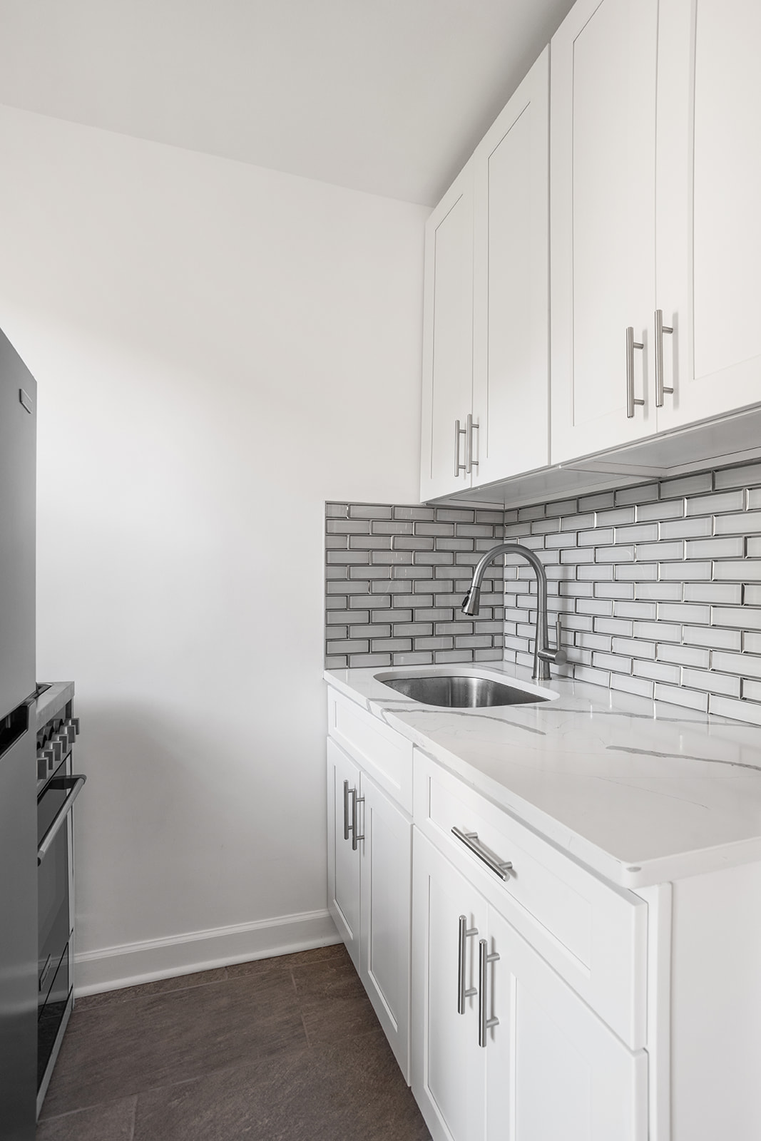 33-35 81st Street, Unit 5A Queens, NY 11372 - Photo 4 of 12 a kitchen with granite countertop white cabinets and white appliances