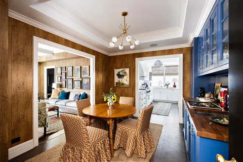 a view of a dining room with furniture a chandelier and wooden floor