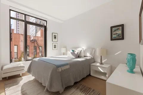 a bedroom with a bed and a large window