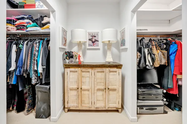 a view of walk in closet with clothes and shoes