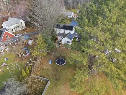 an aerial view of a house with a yard and large tree