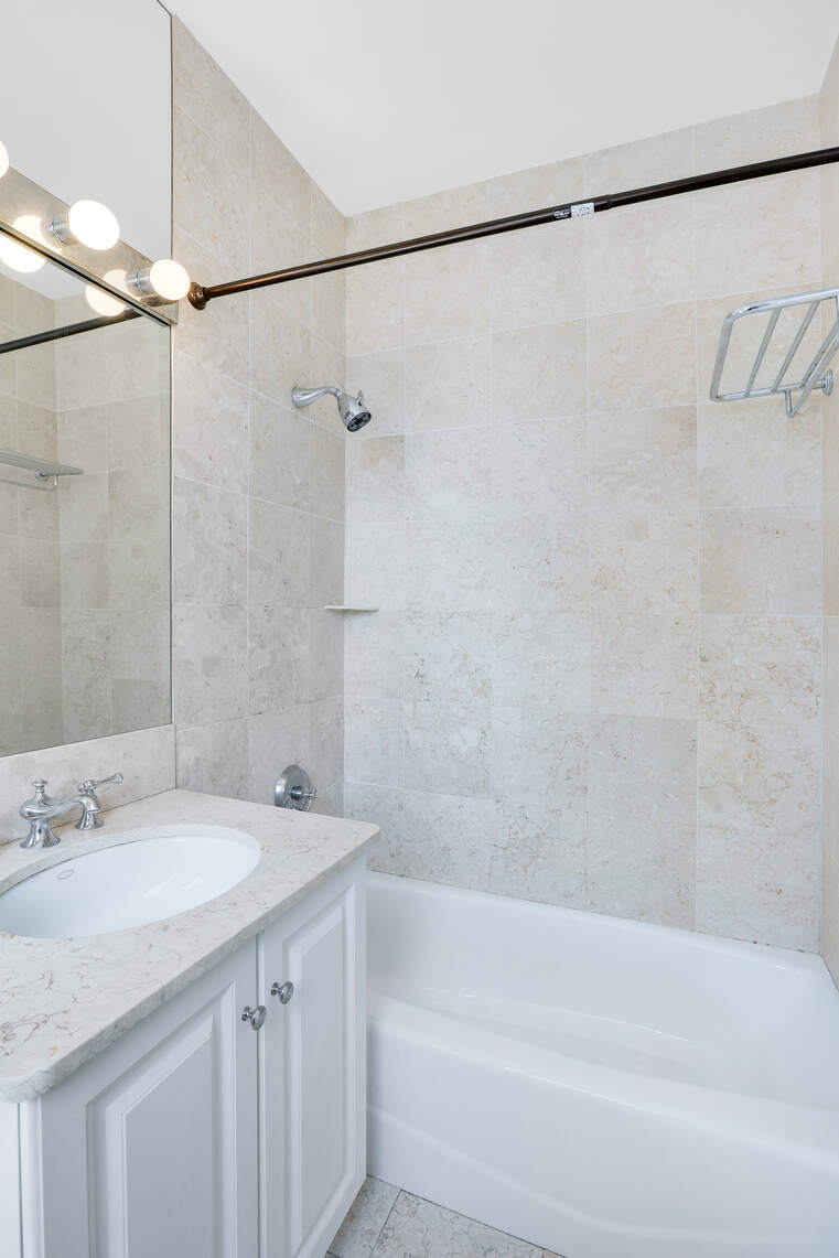 2 Columbus Avenue, Unit 17C Manhattan, NY 10023 - Photo 9 of 26 a bathroom with a granite countertop sink and a bathtub