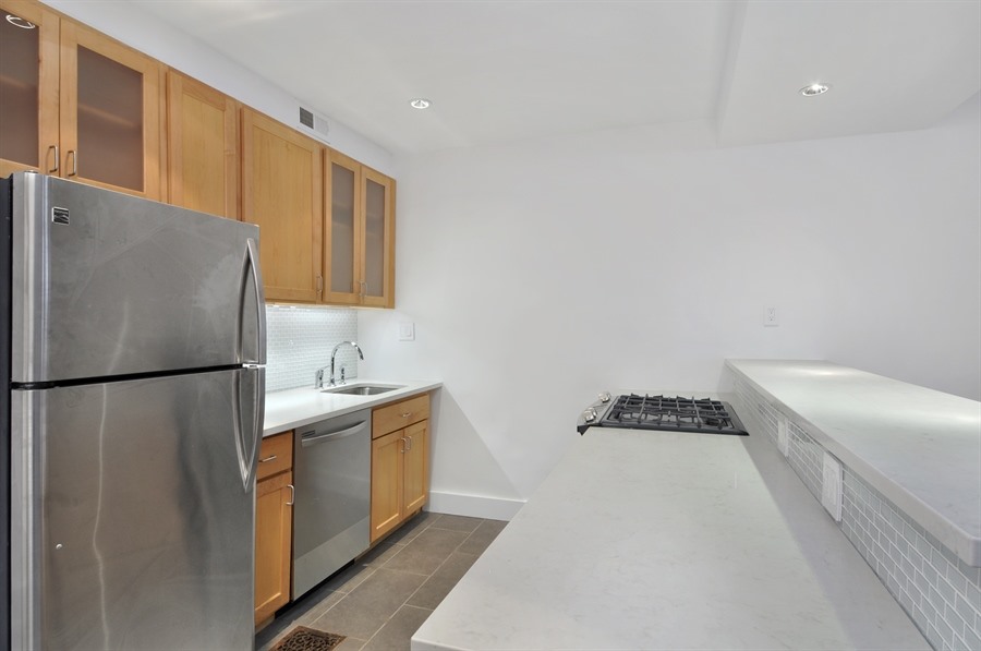383 Grand Avenue Brooklyn, NY 11238 - Photo 28 of 32 a kitchen with stainless steel appliances a refrigerator a sink and white cabinets