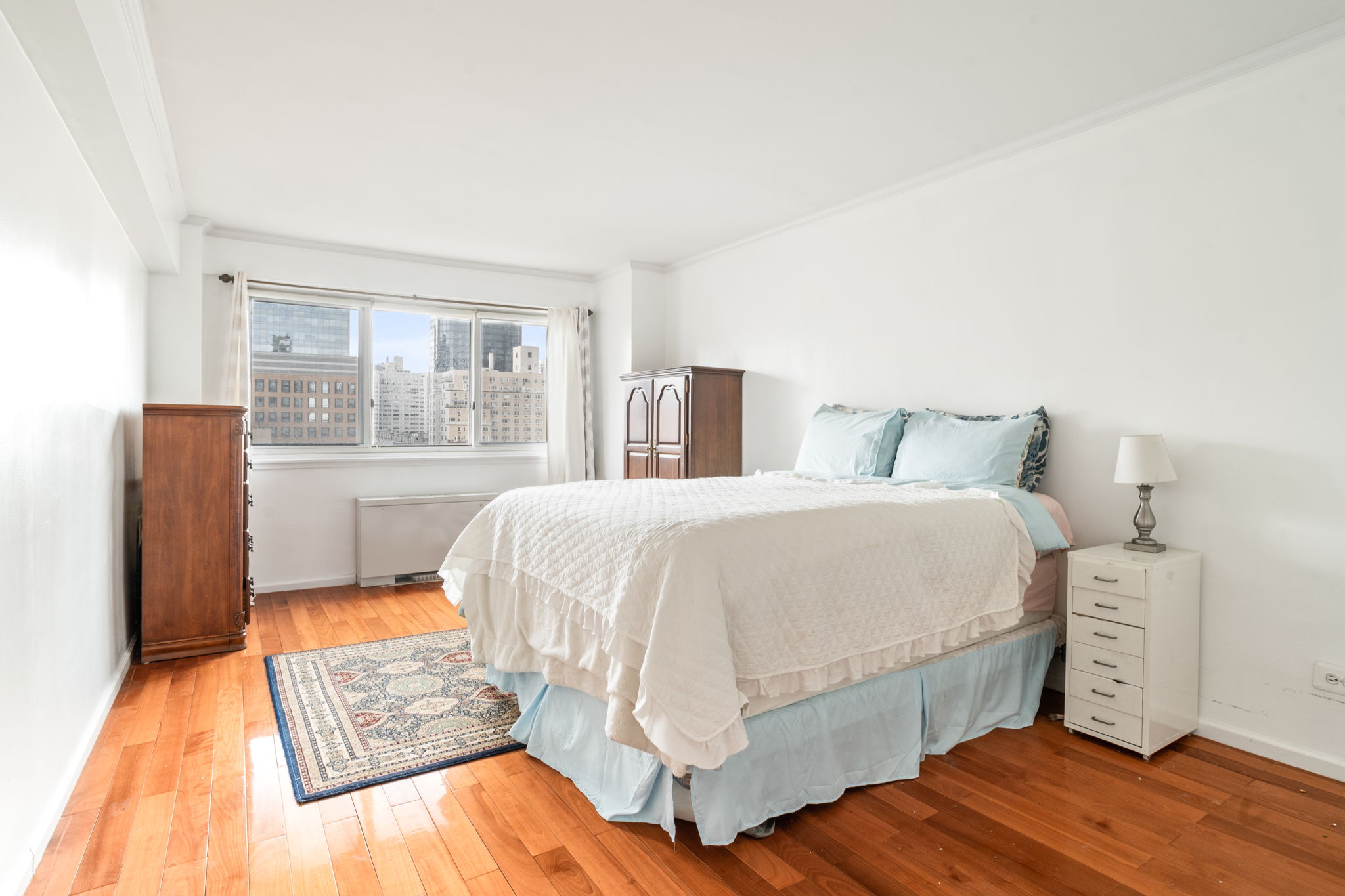 401 East 65th Street, Unit 12F Manhattan, NY 10065 - Photo 7 of 18 a bedroom with a bed and wooden floor
