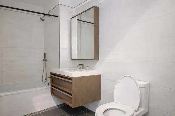 a bathroom with a sink a toilet and shower