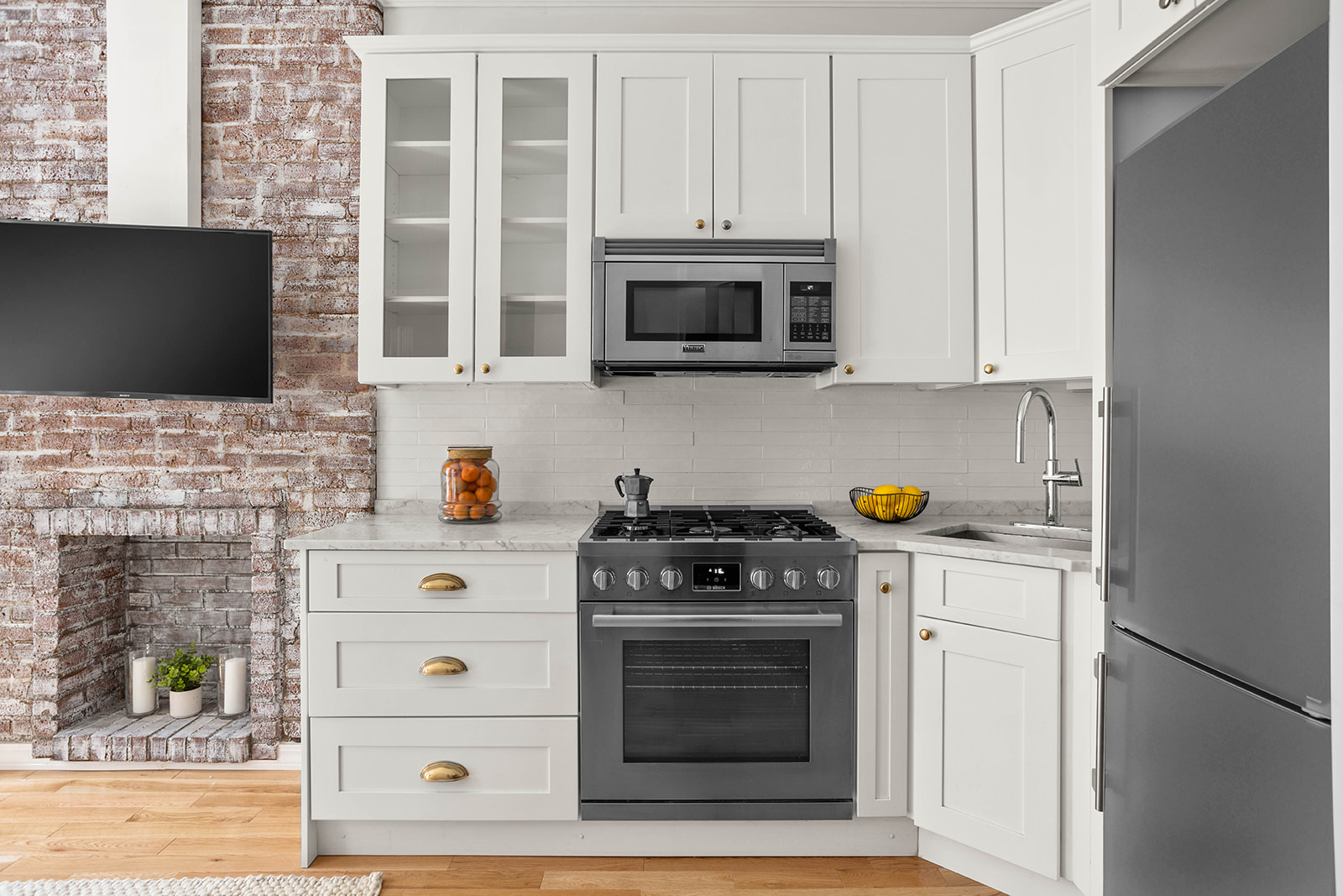 227 East 87th Street, Unit 1B Manhattan, NY 10128 - Photo 4 of 6 a kitchen with stainless steel appliances a stove a microwave and cabinets