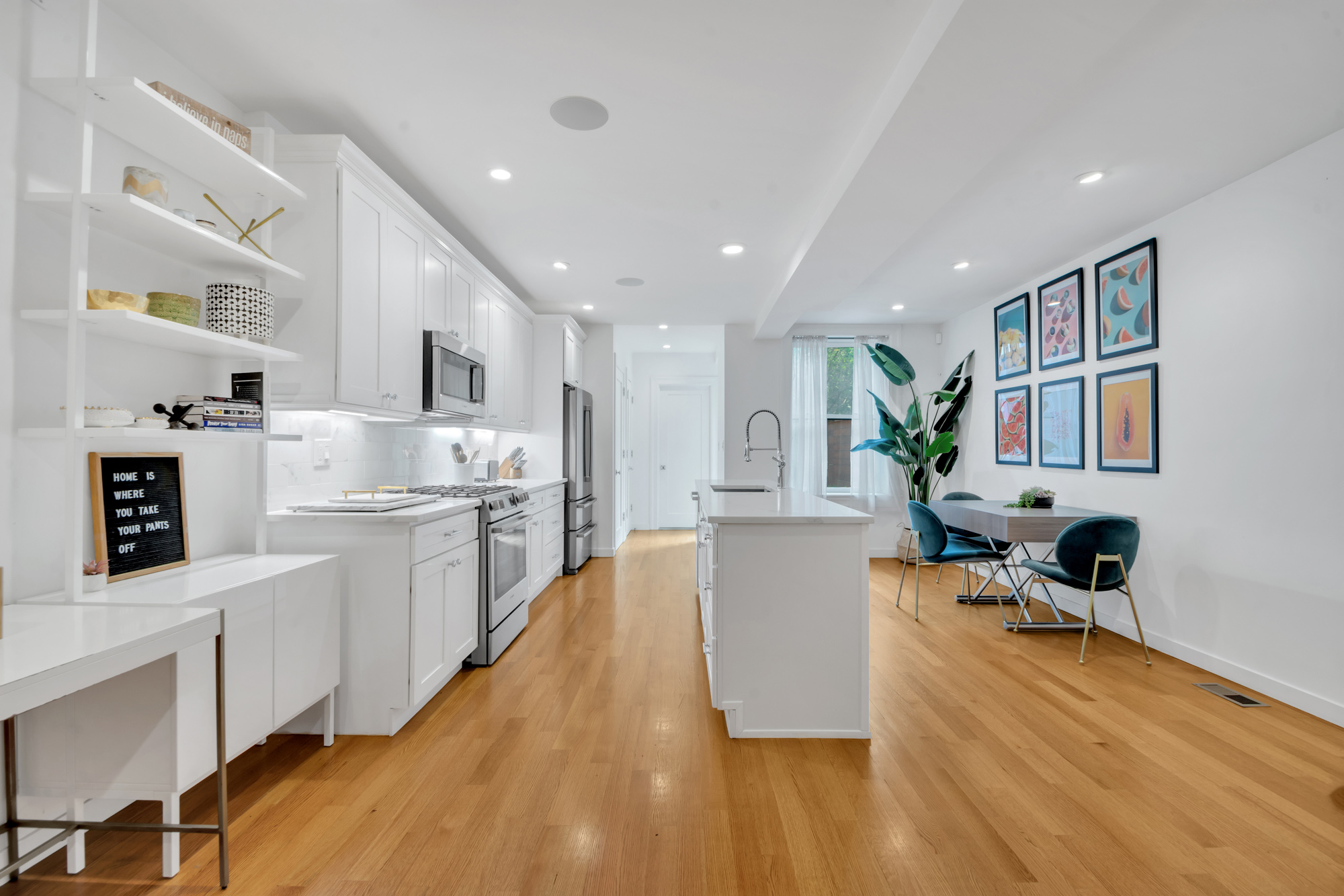 216 West 137th Street, Unit GARDEN Manhattan, NY 10030 - Photo 1 of 13 a large white kitchen with wooden floor and a refrigerator