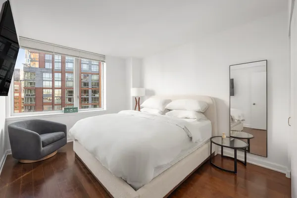a large bed sitting in a bedroom next to a window
