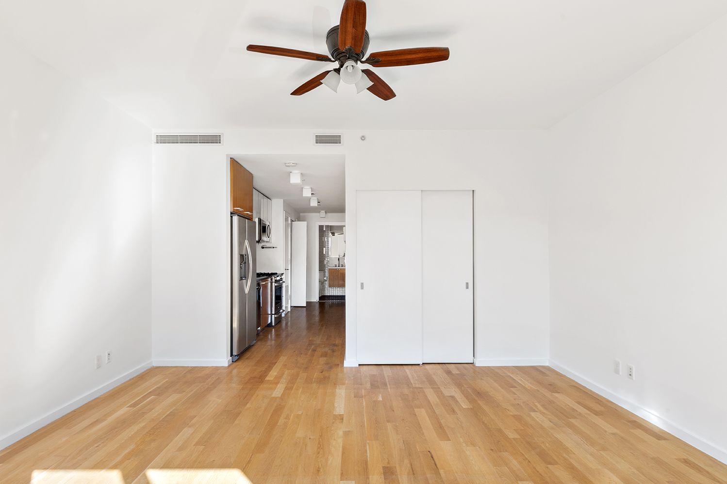 a view of empty room with wooden floor